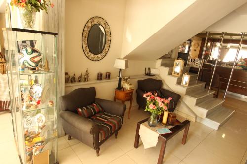 a living room with a couch and a table with flowers at Hotel Mallas in Nea Kalikratia