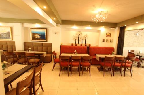 a dining room with tables and chairs in a restaurant at Hotel Mallas in Nea Kalikratia