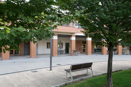 a park bench in front of a building at Albergue Albas exclusivo Peregrinos in Logroño