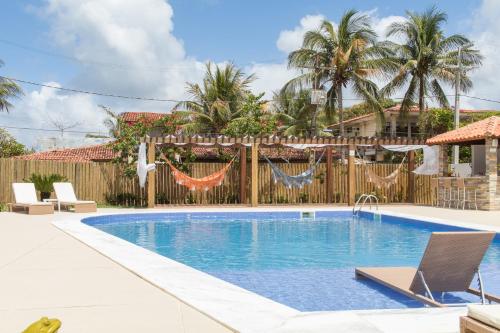 una piscina en un patio trasero con una valla de madera en Wave Suítes Hotel & Lounge bar en Maceió