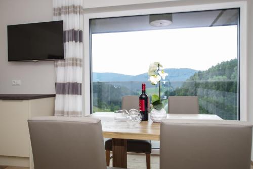 a dining room with a table and a large window at Apartment Hotel Christine in Avelengo