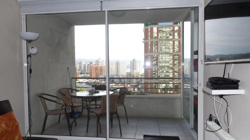 Habitación con balcón con mesa y sillas. en Alto Libertad - Playa las Salinas, en Viña del Mar