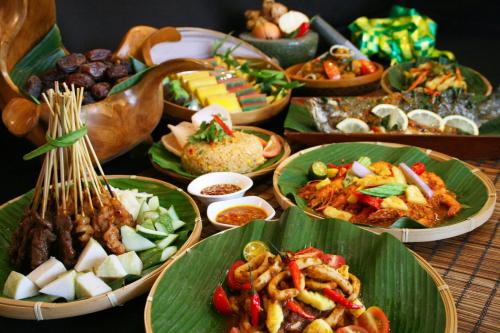 a table with green plates of food on it at Hotel Legend Boutique in Johor Bahru