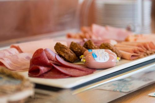a plate of food with bacon and other meats at Hotel Casa Rustica - Eintrittskarten für den Europapark erhalten Sie garantiert über uns! in Rust