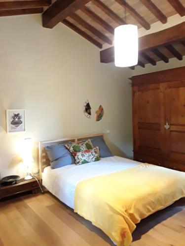 1 dormitorio con 1 cama blanca y suelo de madera en La Breccia di Anghiari, en Anghiari