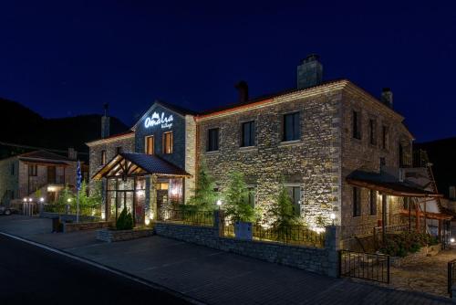 a building with a sign on the side of it at night at Omalia Village in Áno Khóra