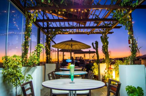 a patio with two tables and an umbrella at Le Foyer Arequipa in Arequipa
