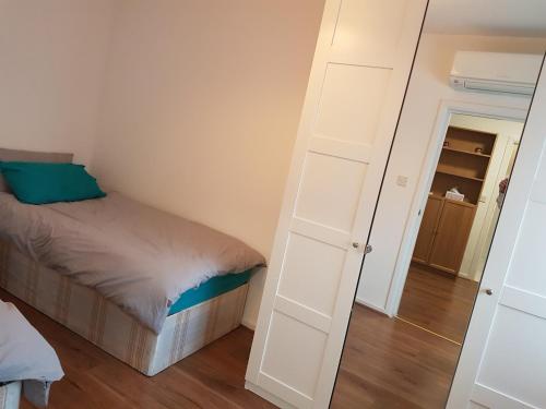 a small bedroom with a bed and a mirror at The Bungalow in London