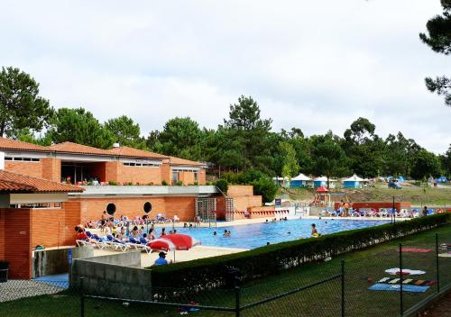 una gran piscina con mucha gente. en Parque de Campismo Orbitur Foz de Arelho., en Foz do Arelho
