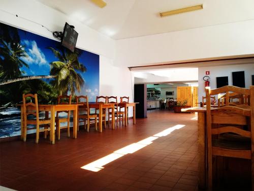 a dining room with tables and chairs and a mural at Parque de Campismo Orbitur Foz de Arelho. in Foz do Arelho