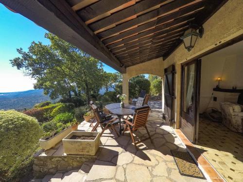 a patio with a table and chairs on a house at Domaine du Bois d'Amont in Cabris