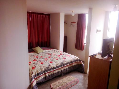 a bedroom with a bed and red curtains at La Casa del Che Fernando in Lima