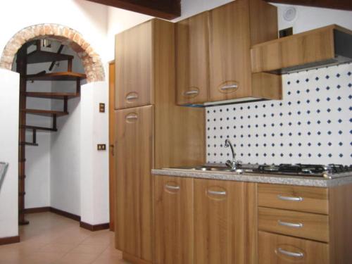 eine Küche mit einem Waschbecken und einer Wendeltreppe in der Unterkunft Altana Piccionaia di Via Dante in Cremona