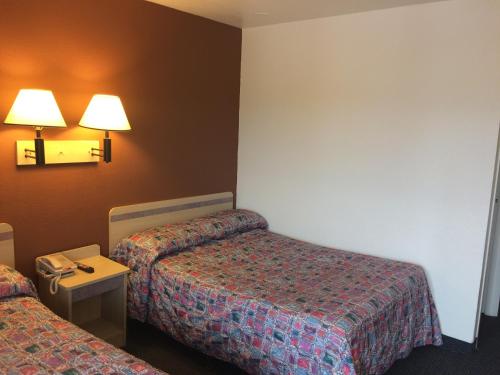 a hotel room with two beds and a table with a phone at Travelodge by Wyndham Raton in Raton