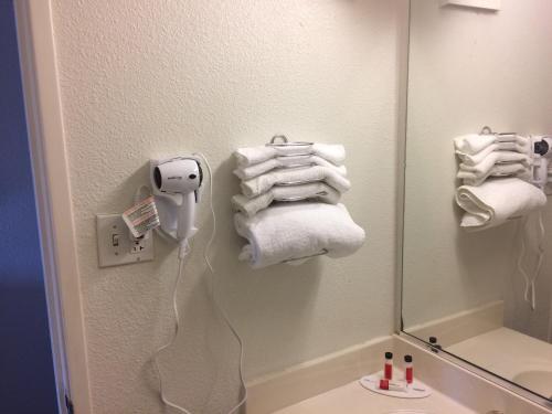 bagno con specchio e asciugamani appesi alla parete di Travelodge by Wyndham Raton a Raton