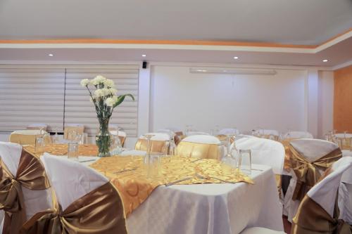 a banquet hall with tables and chairs and a vase of flowers at Hotel Montserrat Plaza in Monterrey