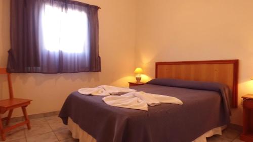 - une chambre avec un lit doté d'une couverture bleue et d'une fenêtre dans l'établissement Dormi's - Adult's Only, à Mina Clavero