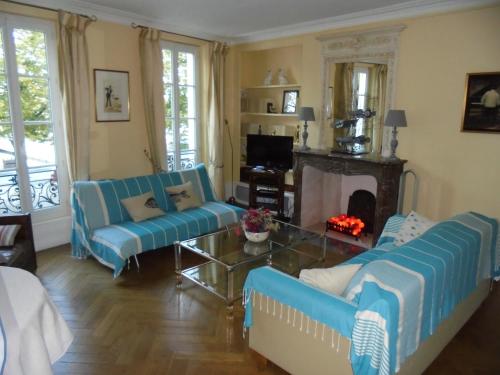 sala de estar con 2 sofás azules y chimenea en Sur Le Vieux Port Appartement Vue Sur Mer, en La Rochelle