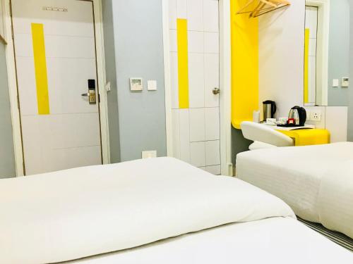 two beds in a room with yellow and white at City Empire New Delhi Train Station in New Delhi