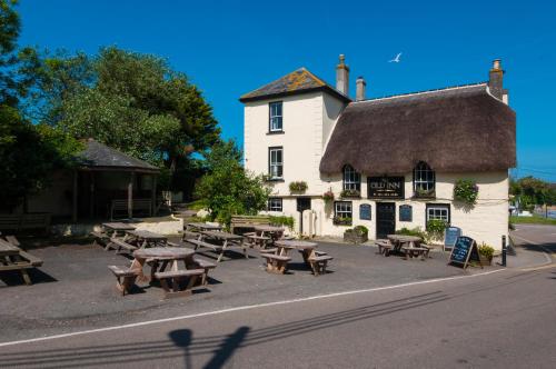 a group of picnic tables in front of a building at The Old Inn in Mullion