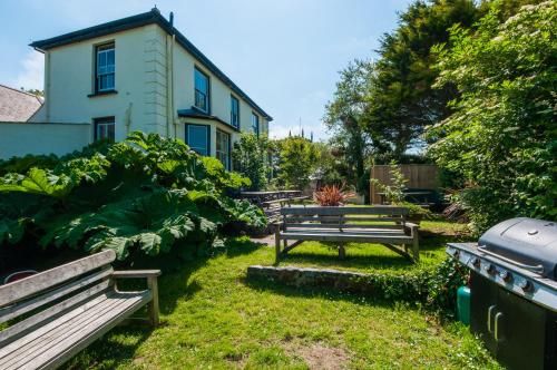 a group of benches in a yard with a building at The Old Inn in Mullion