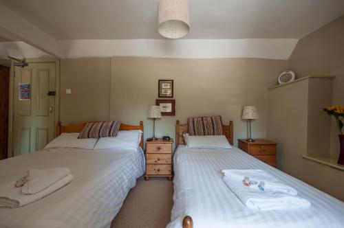 a hotel room with two beds and two lamps at The Old Inn in Mullion