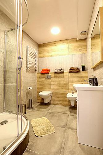 a bathroom with two sinks and a toilet and a shower at Intermo in Świętochłowice