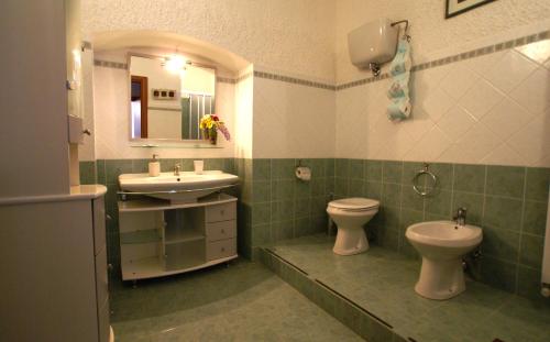 a bathroom with a sink and a toilet and a mirror at Il Querceto in Bosco