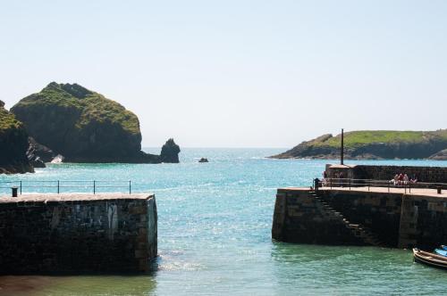 a boat is docked at a pier in the water at The Old Inn in Mullion