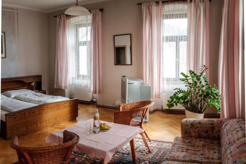 MühldorfにあるGasthof zum Richterのリビングルーム(ベッド1台、テーブル、椅子付)