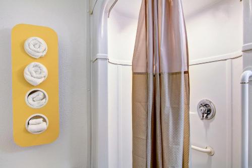 Baño con toallas en la puerta de una ducha en Motel 6-Green Bay, WI en Green Bay