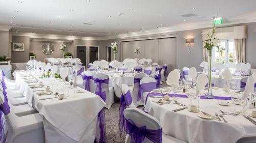 a room with white tables and chairs with purple bows at The Devon Hotel in Exeter