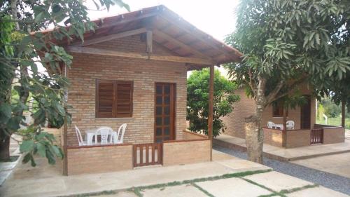 a small house with white chairs on a deck at Pousada Sao Lourenco in Ubajara