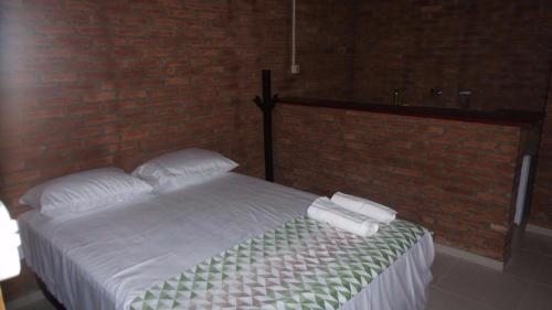 a bedroom with a bed with two towels on it at Pousada Sao Lourenco in Ubajara
