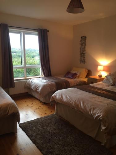 a bedroom with two beds and a large window at Carrick House B&B in Killybegs