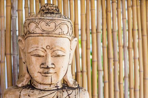 a statue of a head in front of a bamboo wall at Bamboo Bonaire by Boutique Bonaire Unique Resorts in Kralendijk