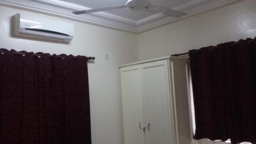a bathroom with a ceiling fan and a window at Woodpecker Resort Hotel in Banjul
