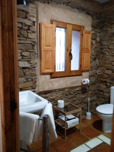 a bathroom with a sink and a toilet and a window at La Posada Del Corralón in Alcoba