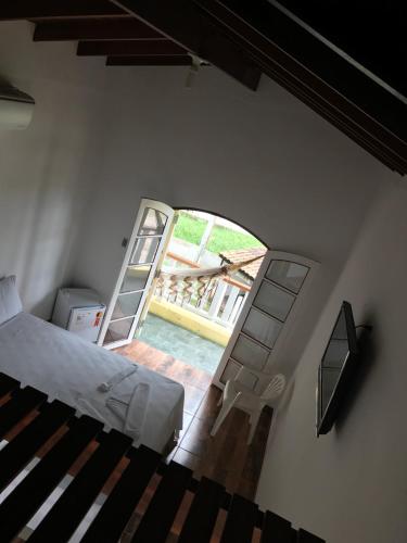 a bedroom with a bed and an open door at Camping Pousada Ilha do Mel - Frente ao Mar in Boracéia