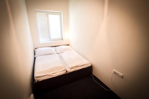 een klein bed in een kleine kamer met een raam bij Apartmány Sázavský ostrov in Sázava