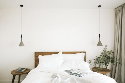 a bedroom with a bed with white sheets and pillows at The Surfrider Malibu in Malibu