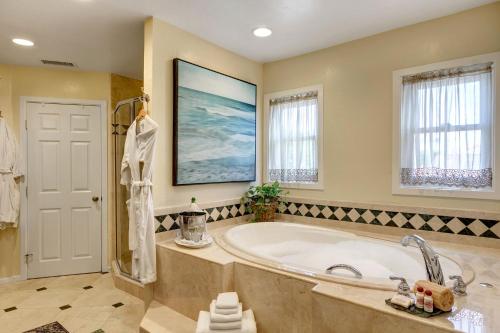 un ampio bagno con grande vasca e finestre di Hillcrest House Bed & Breakfast a San Diego