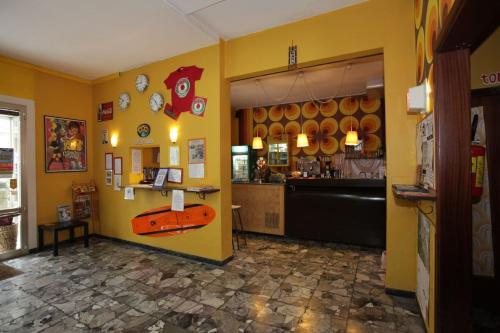 a restaurant with a surfboard on a yellow wall at Sunflower City Youth Hotel in Rimini