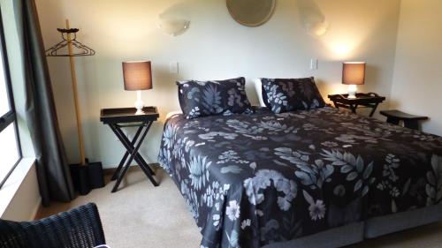 a bedroom with a bed and two lamps on tables at Ashcroft Gardens Bed & Breakfast in Napier