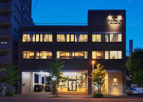 a building with a sign on the side of it at Hotel Potmum Sapporo in Sapporo