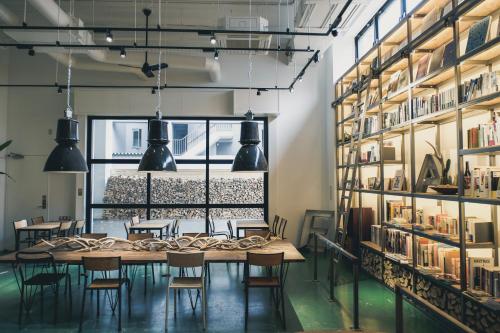 a table and chairs in a room with bookshelves at Hotel Potmum Sapporo in Sapporo