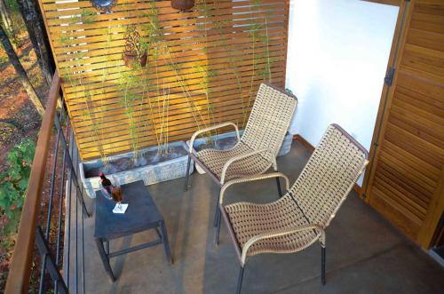 three chairs and a table on a balcony at Serra do Juá Pousada de Campo in Pirenópolis