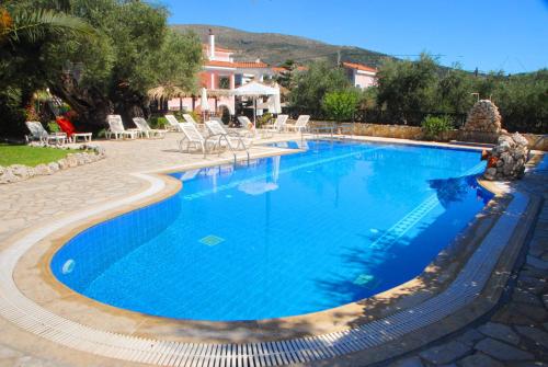a swimming pool with blue water in a resort at Kyprianos in Keri