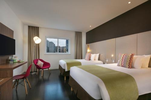 um quarto de hotel com duas camas e uma televisão em Campanile Shanghai Railway Station and People's Square em Xangai