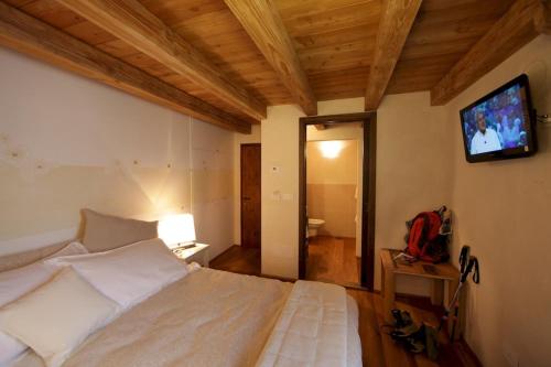 a bedroom with a bed with a television on the wall at Maison Bondaz & SPA privé in Aosta